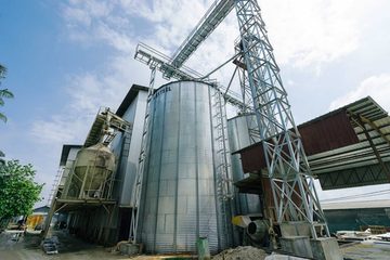 Steel grain silos and conveyor gantries at a QL Resources farm site.