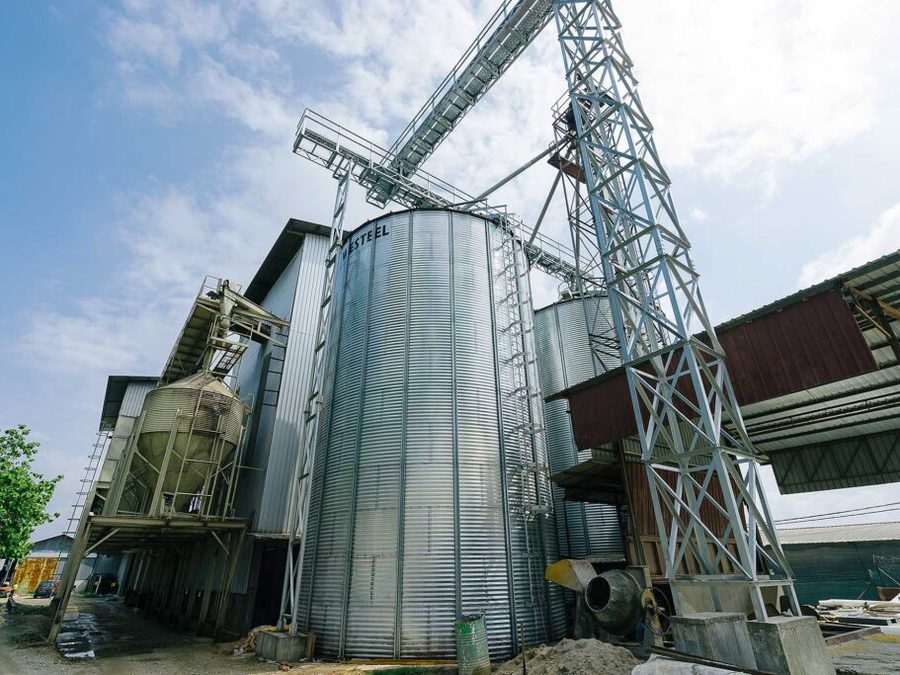 Steel grain silos and conveyor gantries at a QL Resources farm site.